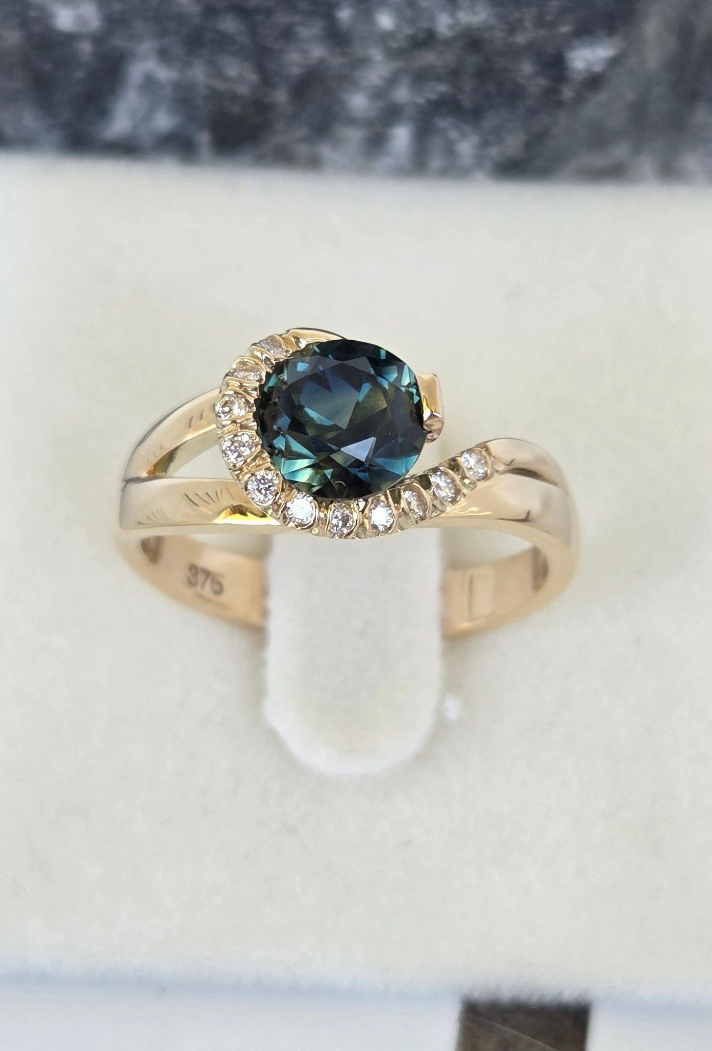 Blue Parti Sapphire custom made ring with diamond set spiral curl surround     Design Ref: #01557